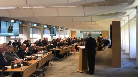 Tim Oliver makes a speech at a meeting of Surrey County Council in the offices at Woodhatch Place in Reigate.