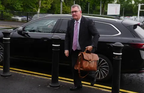 A man in a suit getting out of a car