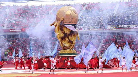 Getty Images Smoke seen over the golden football and dancers around it