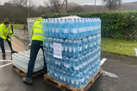 Scottish Water Two men unloading a pallet of bottled water