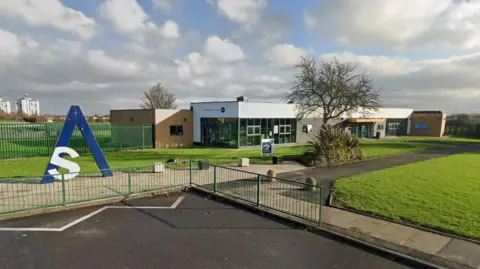Billingham Skills Academy. It is a brick and glass single-storey building. A tree is growing at the front next to a path.