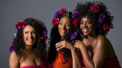 Hush PR Three women from Sister Sledge wearing roses in their hair