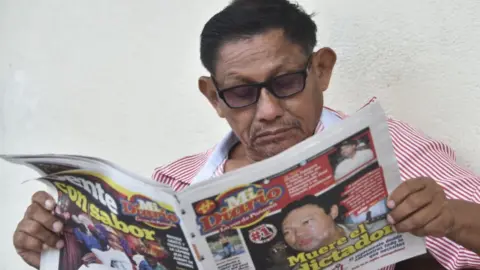 A man reads a Panamanian newspaper on the death of former dictator Manuel Noriega in 2017