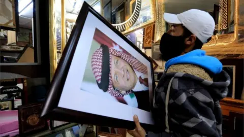 EPA A frame maker in a frame shop displays pictures of King Abdullah II bin Al-Hussein king of Jordan, in Amman, Jordan, 4 April