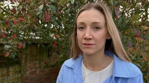 Laura stands in her garden.