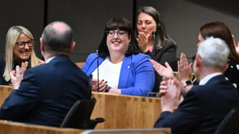 Senedd Cymru New Deputy Presiding Officer Kerry Ferguson in the chamber being applauded by Senedd members.