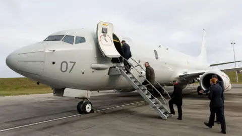 RAF Lossiemouth Five men in uniform are boarding a military jet plane