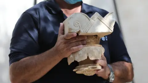 EPA Israeli archaeologist Yaakov Billing displays a stone capital from a palace from the era of a Biblical Jewish kingdom in Jerusalem (3 September 2020)