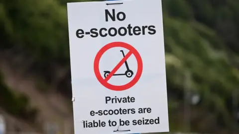 Finnbarr Webster/Getty Images E-scooter warning sign in Bournemouth