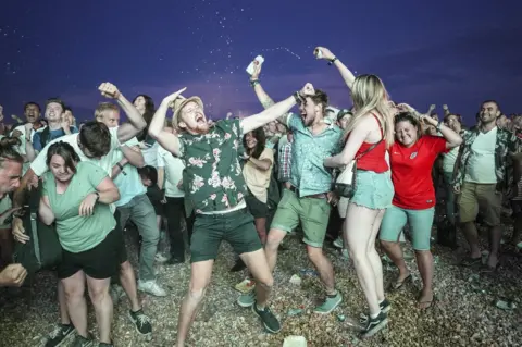 Getty Images England fans celebrate on Brighton beach