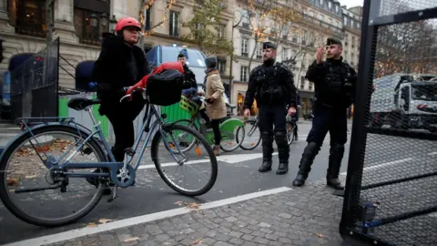 Reuters A woman walks with a bicycle as French police block a street near the Place de la Concorde in Paris