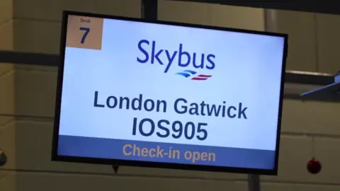 A screen in Newquay Airport showing details for a Skybus flight to London Gatwick.