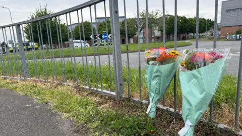 Floral tributes left at the side of the road near the incident.