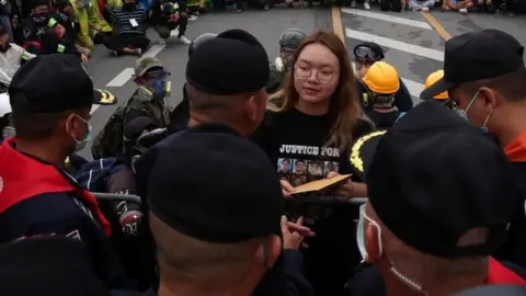 Reuters A student protest leader hands over a letter to Royal Guard police, with demands for reforming the monarchy