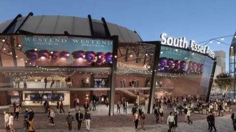 A CGI image of what the new arena could look like. It is a bowl-shaped building that is made of brown bricks and has a grey roof. Festoon lights are hanging off various parts of the building, which has a crowd of people milling about outside it. There is a neon sign that says "South Essex Arena" above one entrance.
