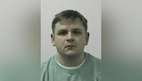 Mugshot of the rapist who has fair hair and is wearing a grey top