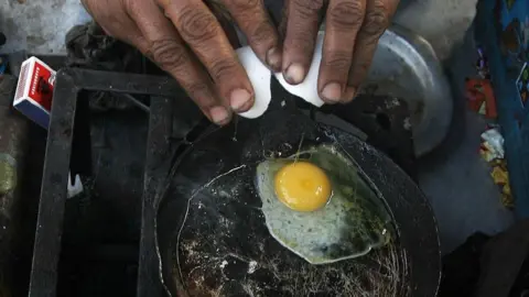 Getty Images An Indian woman makes an omelette in Kolkata