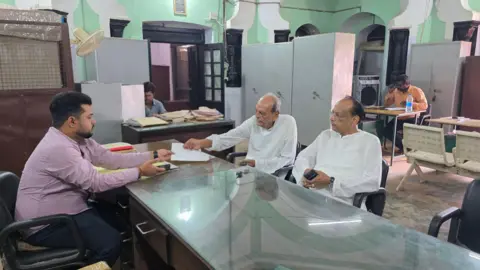 Aman/BBC  Faiyaz Ali Khan and Shikoh Azad sitting inside the  Hussainabad Trust Office in Lucknow to collect their pension