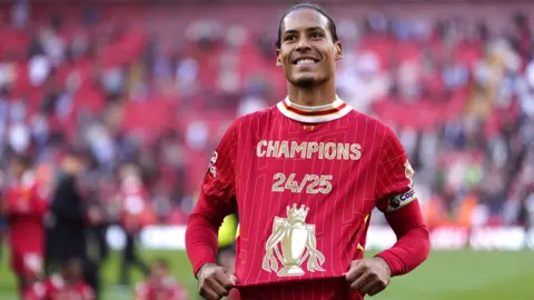 Liverpool captain Virgil van Dijk wearing a red t shirt that says Champions 24/24 on it