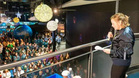 Martyn Milner Woman on a balcony speaking to large group of scouts below