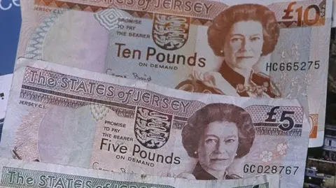 BBC A Jersey £10 and £5 note with a picture of Queen Elizabeth II on them.