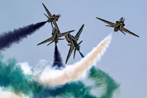 Khaled Desouki /AFP Pesawat latih BAE Hawk milik tim aerobatik Saudi Falcons Angkatan Udara Kerajaan Saudi mengeluarkan asap saat melintas di udara