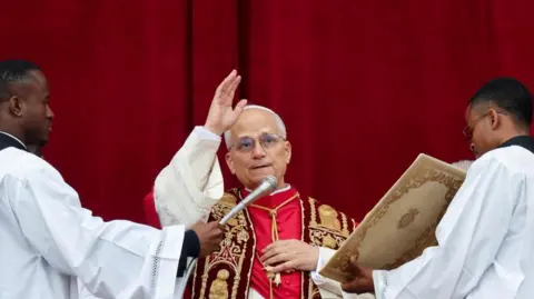 Reuters Pope Leo speaking into a microphone during his Christmas address and holding his hand in the air