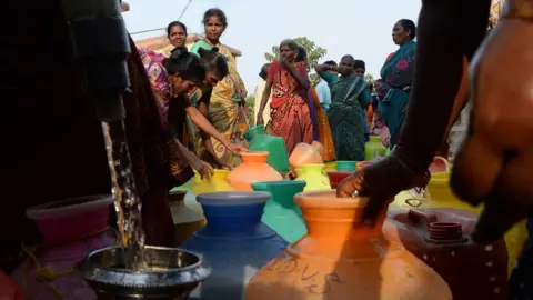 Getty Images People collect water in bottles