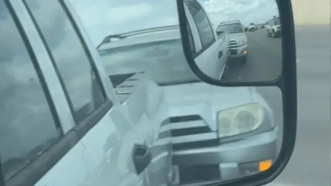 Two vehicles are bumper to bumper on the highway.