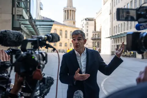 Getty Images Picture of Matt Brittin stood outside the BBC, with cameras facing him. He wears a dark suit jacket with an open shirt and no tie.