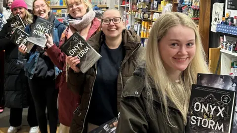 Waterstones Young women queue to buy copies of Onyx Storm at Waterstones in Warrington, holding their books