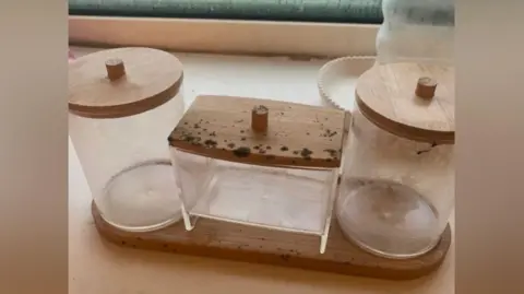 Mould covering a set of three glass cannisters. 