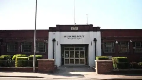 Exterior shot of the Burberry manufacturing site in Castleford, Leeds. The Art Deco building features a Burberry sign on a white facade.