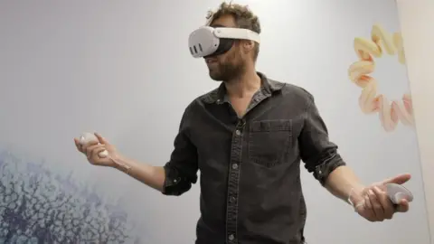 BBC Man plays VR game in headset