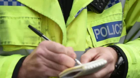 PA Media Police man with notebook