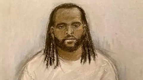 PA Media A court sketch of Jay Emmanuel-Thomas. He has long, black hair and a beard. He is wearing a grey sweater and looking forwards with no expression.