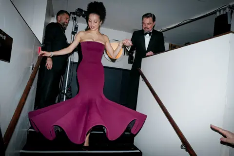 Getty Images Chase Infiniti y Leonardo DiCaprio detrás del escenario, él la está ayudando a bajar unas escaleras.