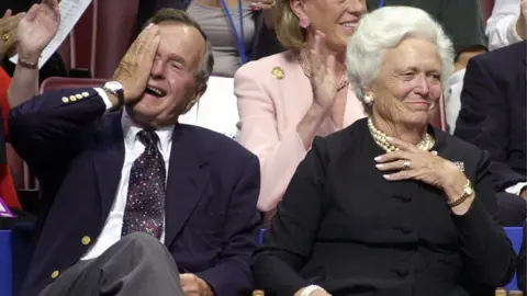 Getty Images Former US President George Bush (L) waves, as he is accompanied by former US First Lady Barbara Bush, during the evening session of the 2000 Republican National Convention in Philadelphia's First Union Center 31 July, 2000.