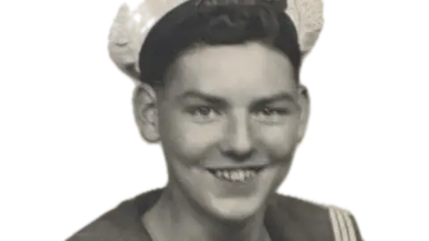 A black and white image of Richard Wood's head and shoulders in his naval uniform, including his white peaked cap.
