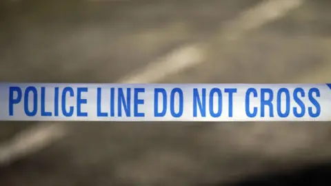 A close-up photo of a blue and white police tape