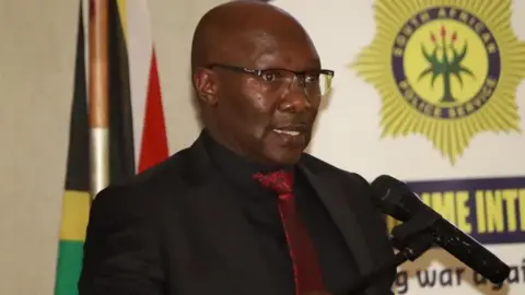 Lt-Gen Dumisani Khumalo in black suit and red tie 
