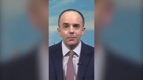 Health Secretary James Murray wearing suit and tie