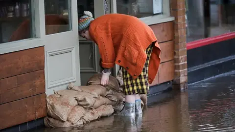 Reuters Woman stacking sandbags in Northwich