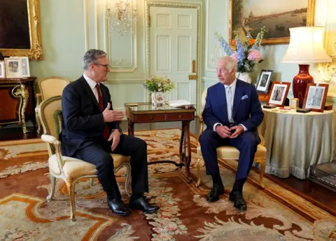 Reuters Sir Keir Starmer and King Charles sit and talk in Buckingham Palace