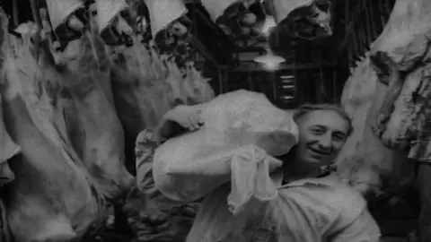 British Pathe A man carrying meat