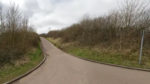 Google The entrance to Rock Road in Wick showing hedges either side of a single-track road