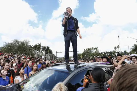 Getty Images Cameron Kasky speaking to a rally at Marjory Stoneman Douglas High School after participating in a county wide school walk out