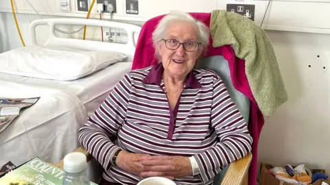 Gwendaline Bawden sitting next to her hospital bed