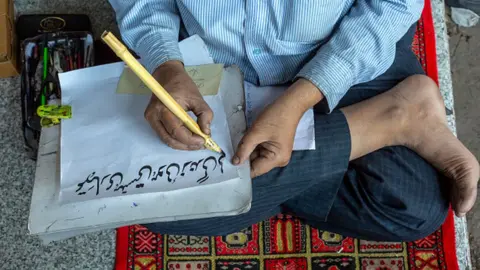 Getty Images Mohammed Ghalib, a katib - traditional calligrapher - in Urdu Bazaar, Old Delhi, India.