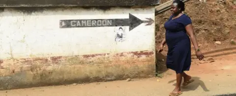 AFP A woman walks into Nigeria from Cameroon at a checkpoint border between Cameroon and Nigeria, in Mfum, in Cross Rivers State